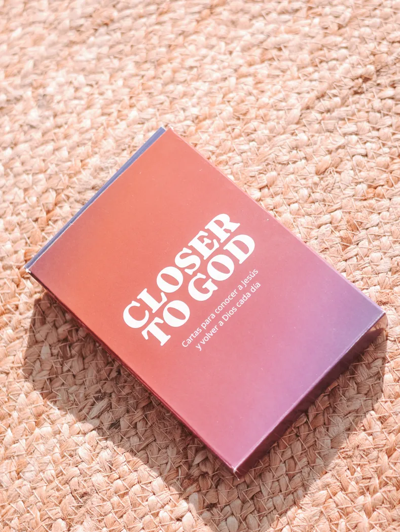 La caja de Closer to God sobre una alfombra de yute