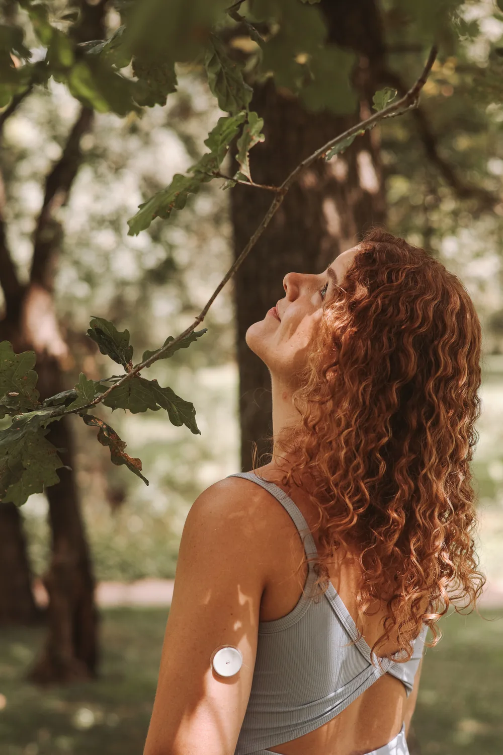 Fabiana en el bosque, mirando hacia la luz entre las ramas