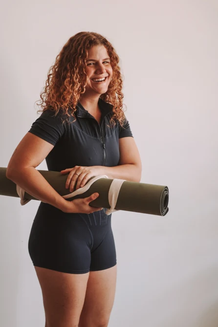 Fabiana riendo con su esterilla de yoga bajo el brazo